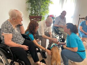 Residentes de la Residencia San Juan de Dios de Priego de Córdoba acariciando a un perro de terapia junto al equipo de WECAN Córdoba