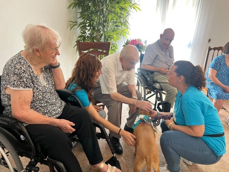 Residentes de la Residencia San Juan de Dios de Priego de Córdoba acariciando a un perro de terapia junto al equipo de WECAN Córdoba